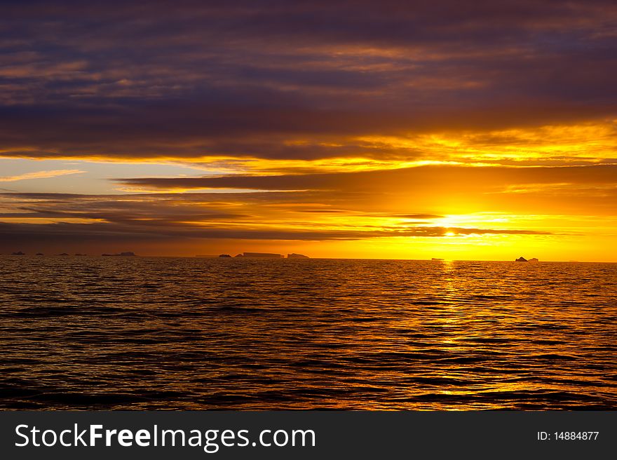 Sunset in atlantic ocean with icebergs. Sunset in atlantic ocean with icebergs