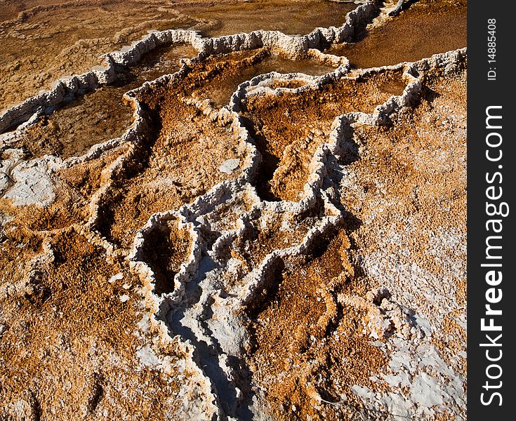 The Mammoth Hot Springs in Yellowstone National Park feature travertine terraces formed from limestone. Thermal waters rise through the limestone, carrying high amounts of dissolved carbonate. At the surface, carbon dioxide is released and calcium carbonate is deposited as travertine, the chalky white rock of the terraces. Due to the rapid rate of deposition, these features constantly and quickly. The Mammoth Hot Springs in Yellowstone National Park feature travertine terraces formed from limestone. Thermal waters rise through the limestone, carrying high amounts of dissolved carbonate. At the surface, carbon dioxide is released and calcium carbonate is deposited as travertine, the chalky white rock of the terraces. Due to the rapid rate of deposition, these features constantly and quickly