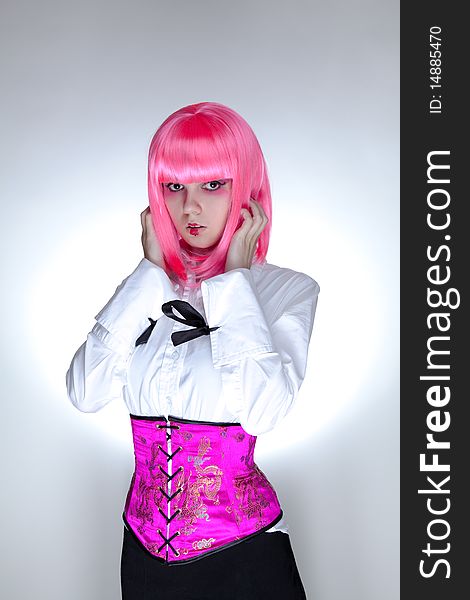 Young surprised woman dressed in oriental corset, studio shot over white background