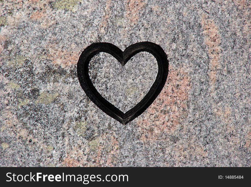 Black heart shape in a background of stone. Black heart shape in a background of stone