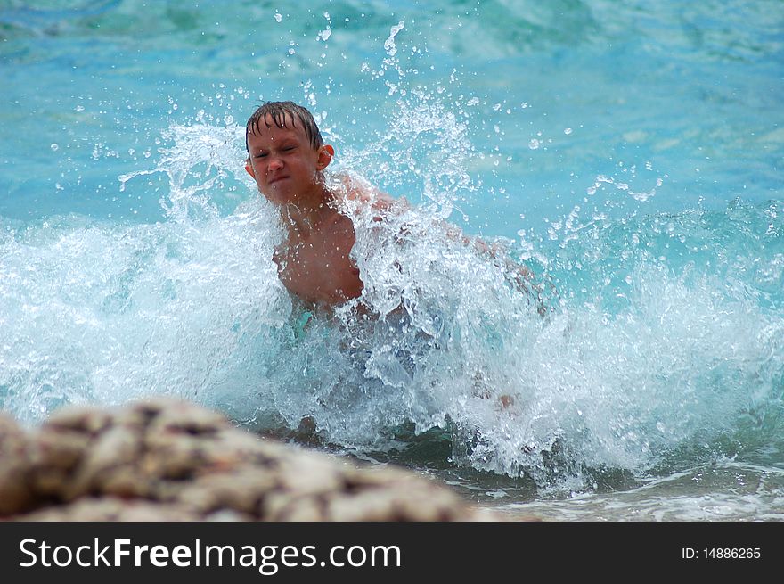 A boy is having fun in Adriatic water on Hvar island, Croatia