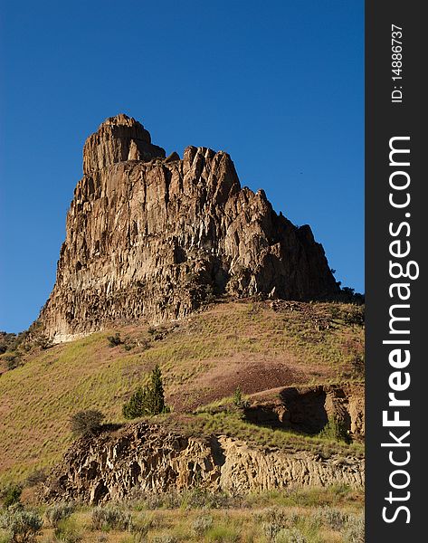 A magnificent outcropping of basalt stands against the blue sky in the eastern Oregon desert. A magnificent outcropping of basalt stands against the blue sky in the eastern Oregon desert
