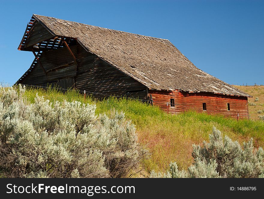 A red barn in a field of sagebrush in the desert of eastern Oregon. A red barn in a field of sagebrush in the desert of eastern Oregon