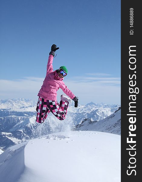 Snowboarder jumping on top of the mountain