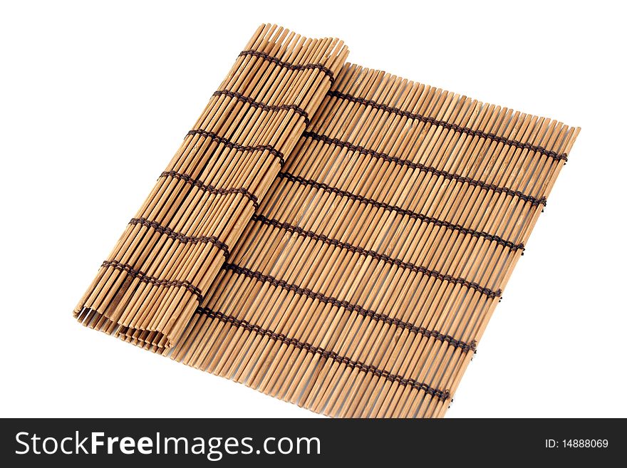Rolled bamboo mat and a pair of chopsticks inside it isolated on white background. Rolled bamboo mat and a pair of chopsticks inside it isolated on white background