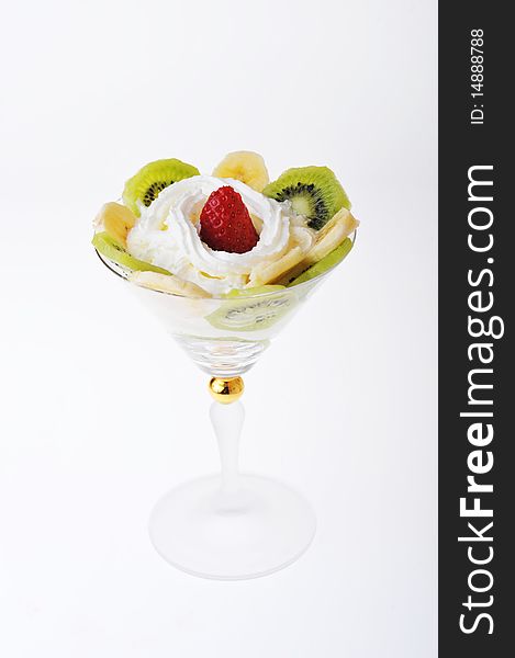 Fresh chopped strawberries, kiwi and banana with whipped cream in glasswares. Fresh chopped strawberries, kiwi and banana with whipped cream in glasswares