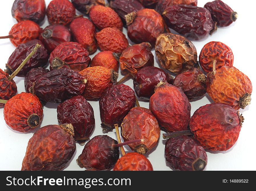 Dried berries of a dogrose on a white background in a heap