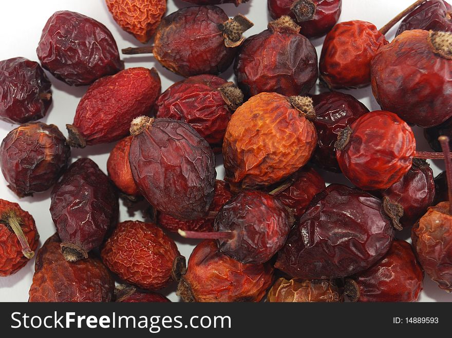 Dried berries of a dogrose on a white background in a heap