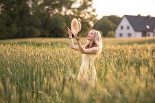 Sunset In Summer.Rural Life.A Young Woman In The Field Throws A Hat. Rustic Style Stock Image