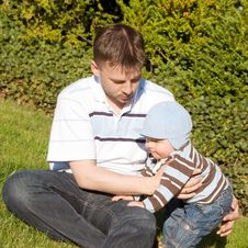 Father And Son On The Grass Stock Photo