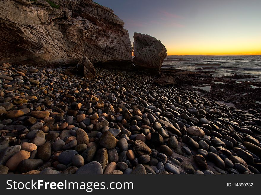 Image of pebbles on a beach take at sunrise on the South African coast line. Image of pebbles on a beach take at sunrise on the South African coast line