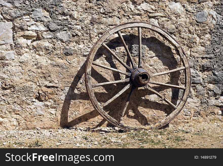 Wheel at a brickwall wagon stone wall.