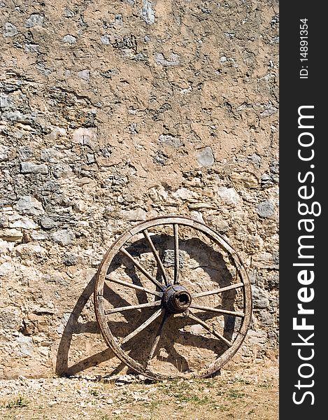 Wheel at a brickwall wagon stone wall.