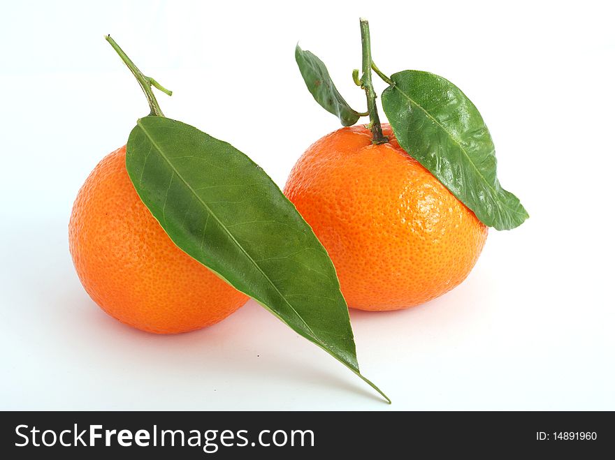 Tangerine with green leaves and water drops isolated on white