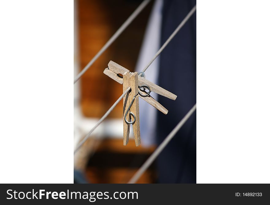 Two wooden clothespins on a clothing line, close up