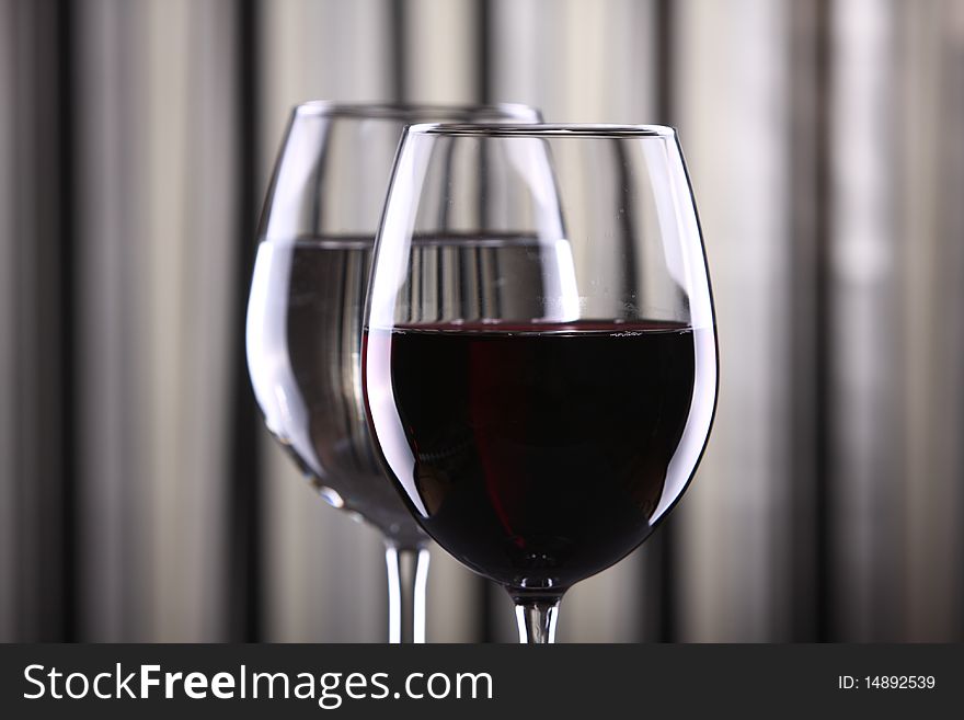 Wine glasses against striped background with dramatic lighting