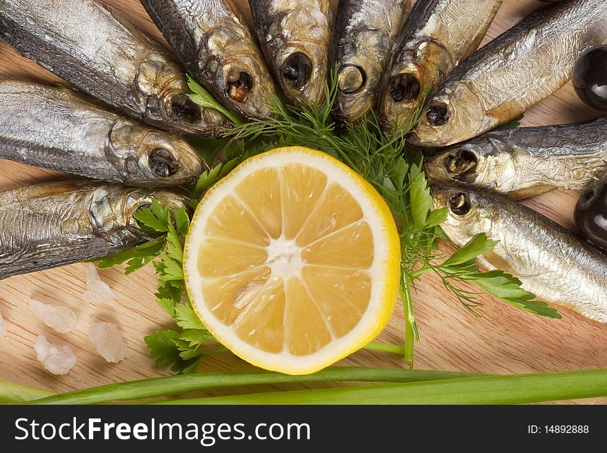 A composition with smoked clupea herring fish (Clupea harengus membras) on wooden plate isolated on white. A composition with smoked clupea herring fish (Clupea harengus membras) on wooden plate isolated on white