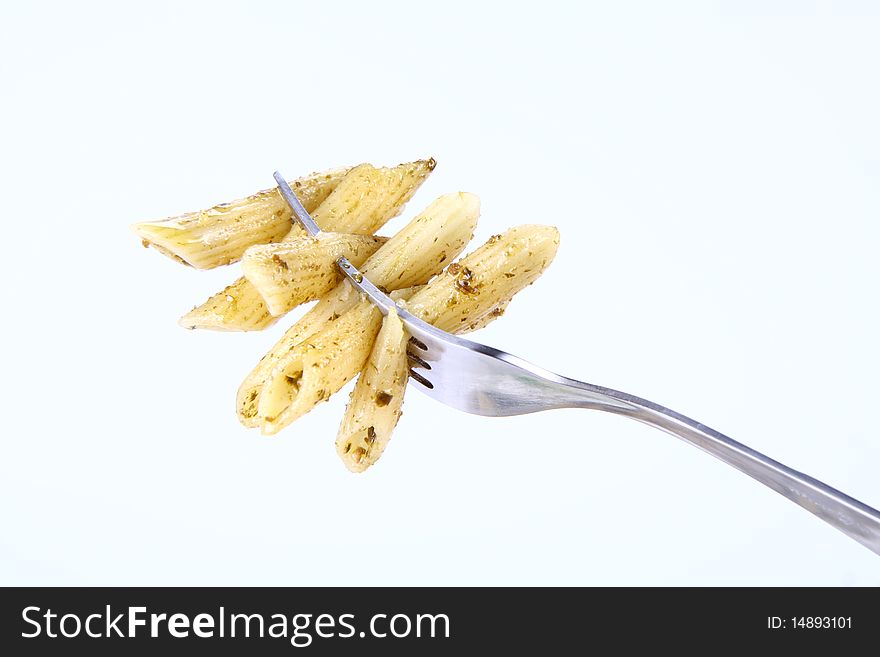 Penne with pesto on a fork