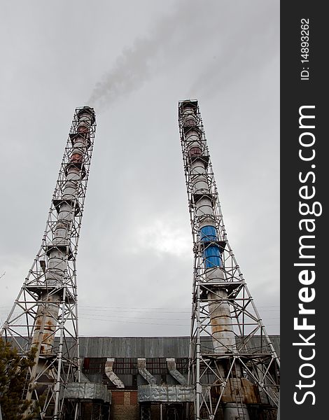 Photo of two smokestacks with dark smoke. Photo of two smokestacks with dark smoke