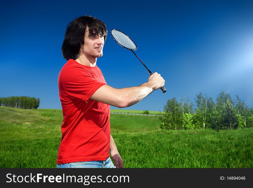 Smiling boy with racket on fields