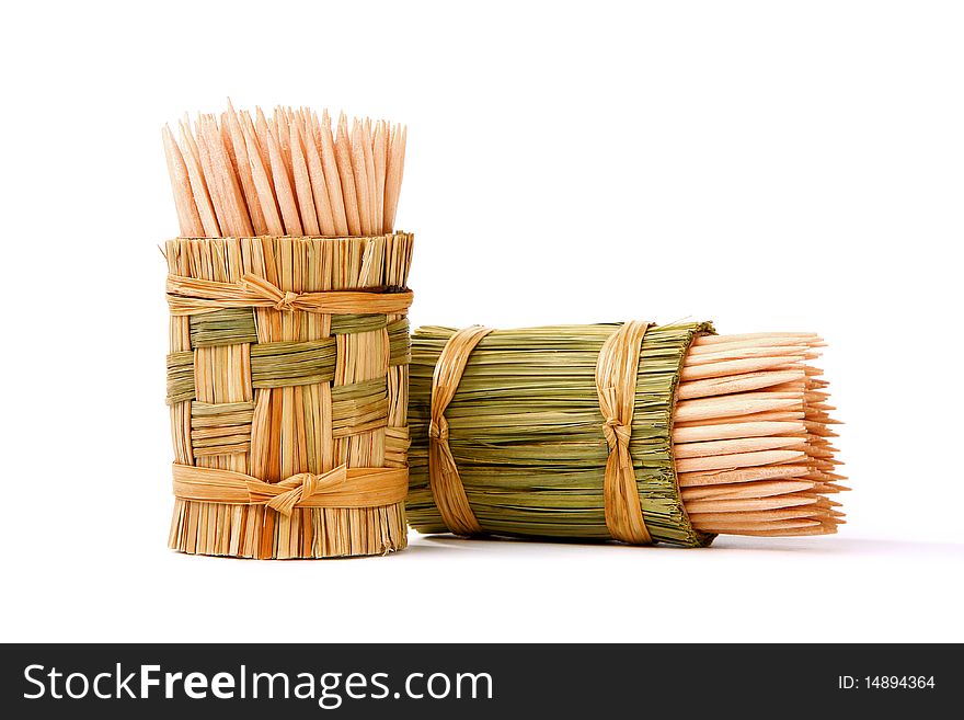 Wooden toothpicks in an original wattled basket on a white background