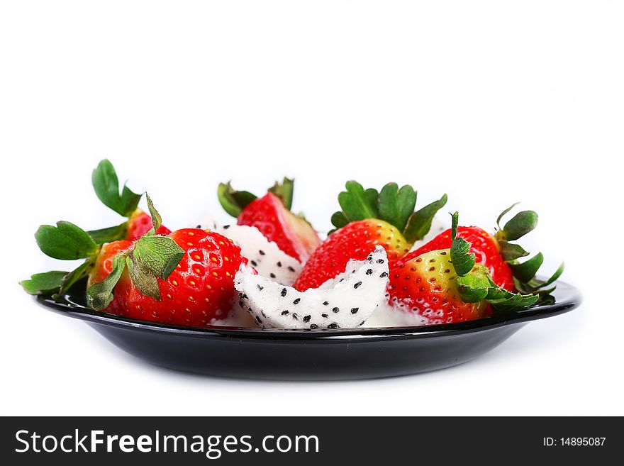 Pitahaya strawberries and cream on a black plate