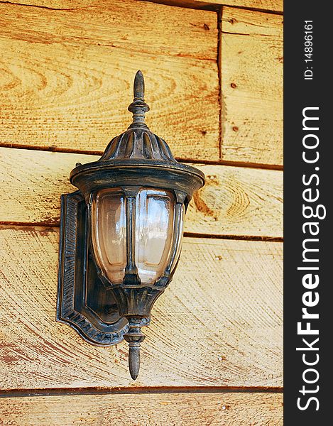 Old fashioned ornamental light on wooden wall. Old fashioned ornamental light on wooden wall