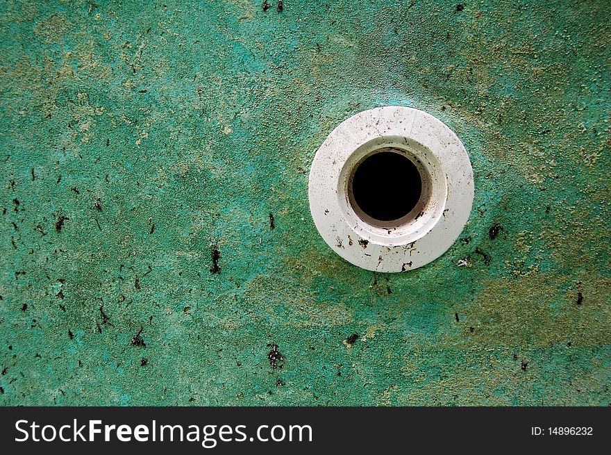 Grunge image of PVC pipe in a green wall