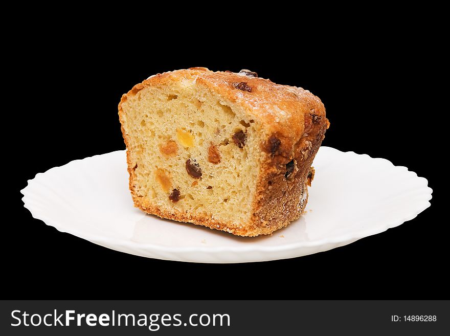 Fruitcake on white plate on black background