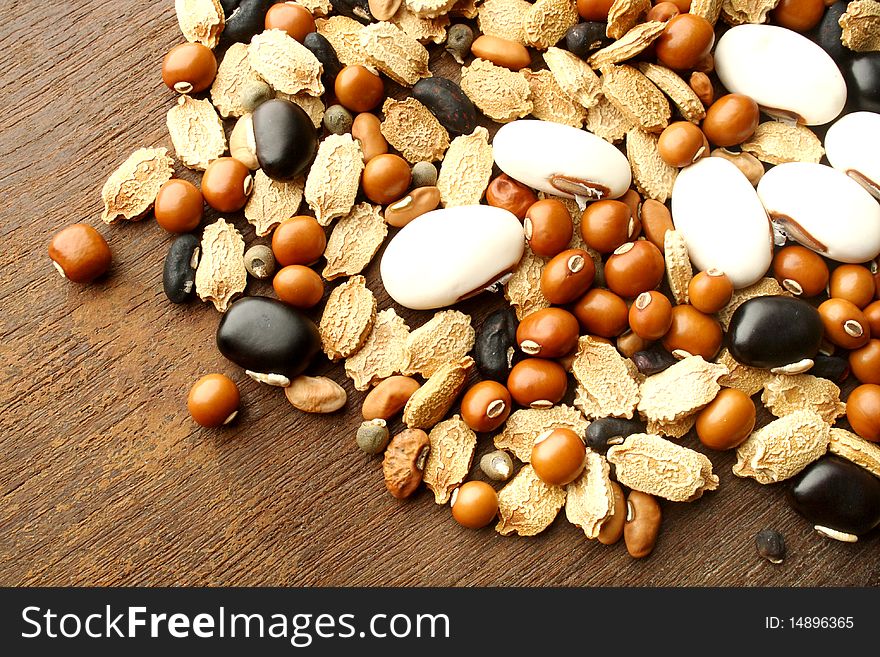 Varieties of farm seeds on a wooden background