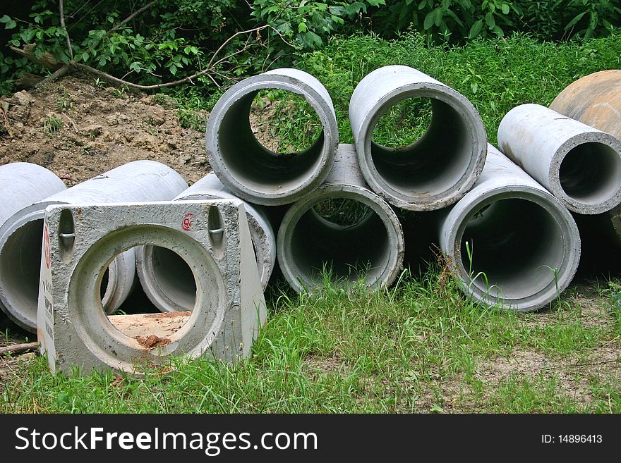 Concrete pipes and fixtures stacked, awaiting use