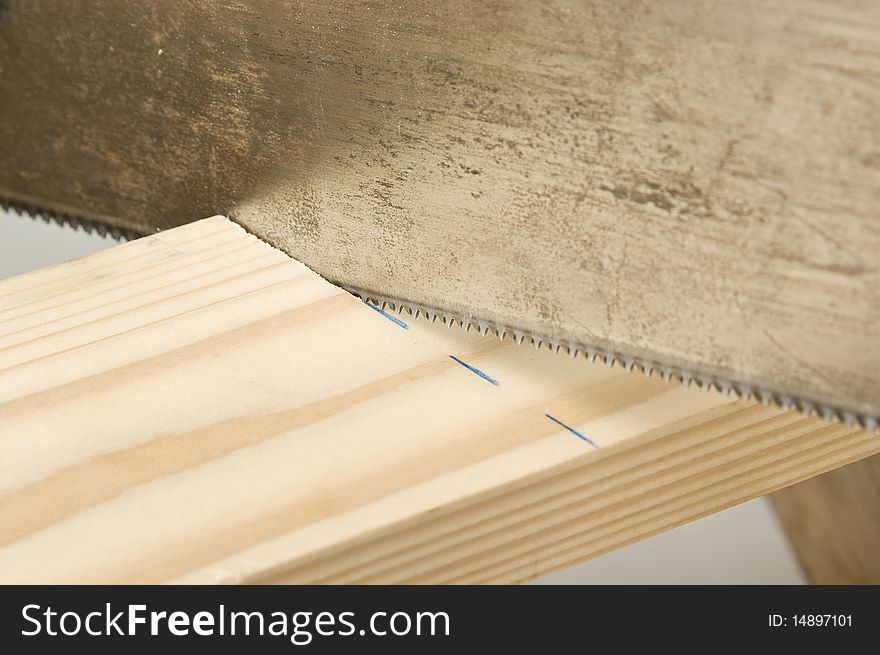 Sawteeth cutting a wooden piece, seen closely