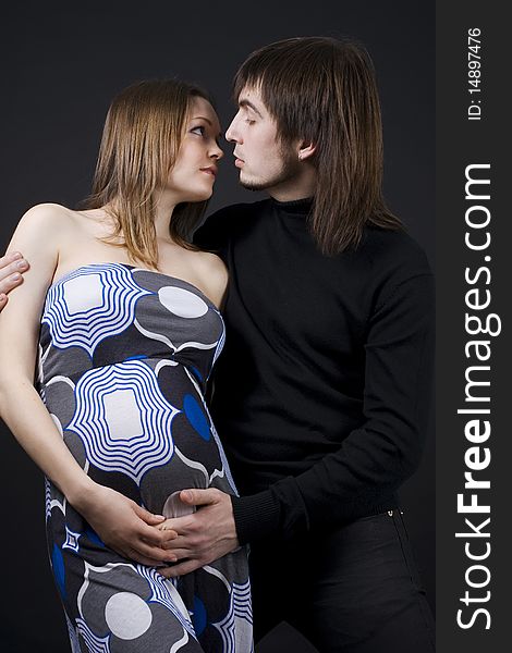 Pregnant couple in loving pose.