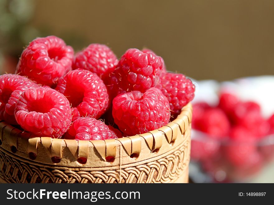 Close up view of raspberries in a wodden decorative bowl. Close up view of raspberries in a wodden decorative bowl