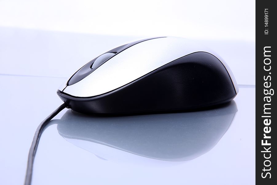 Black and gray computer mouse on reflective surface