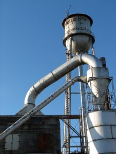 Factory Building With Water Tower And Metal Pipes Stock Photography