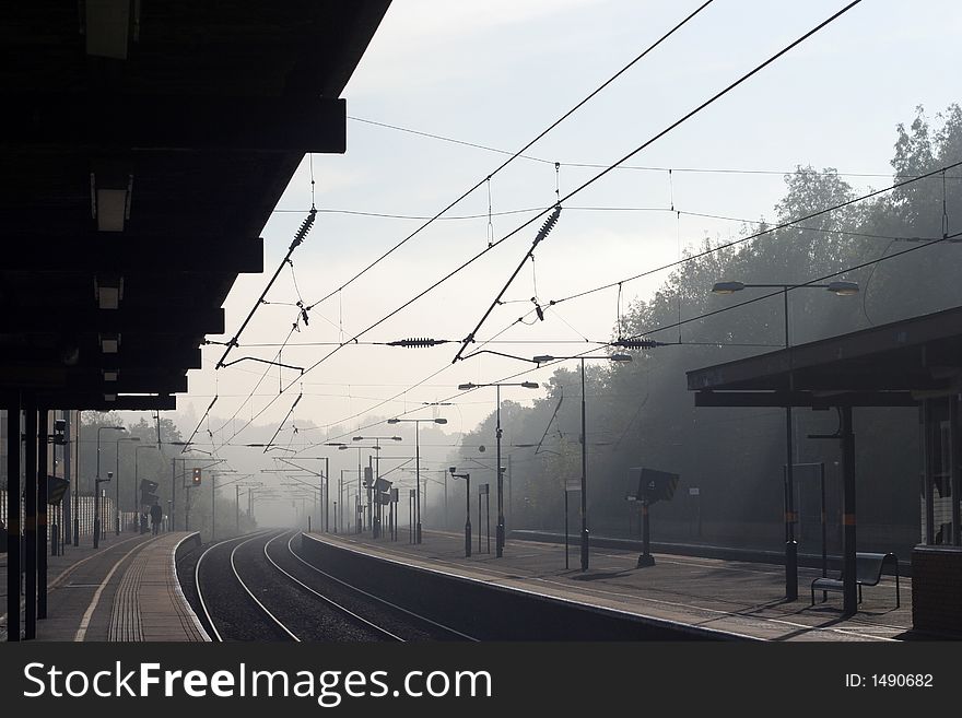 Looking down a railway train station on a misty morning. Looking down a railway train station on a misty morning