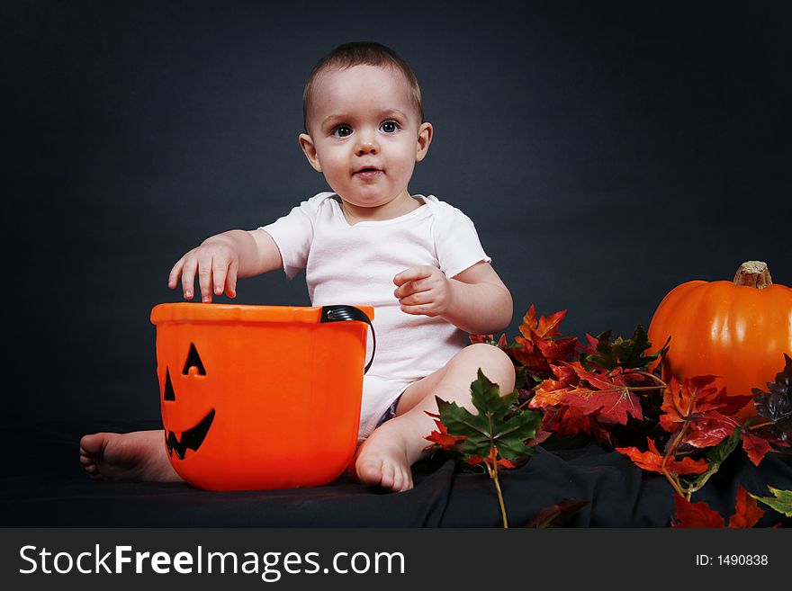 Beautiful baby boy poses on a black background