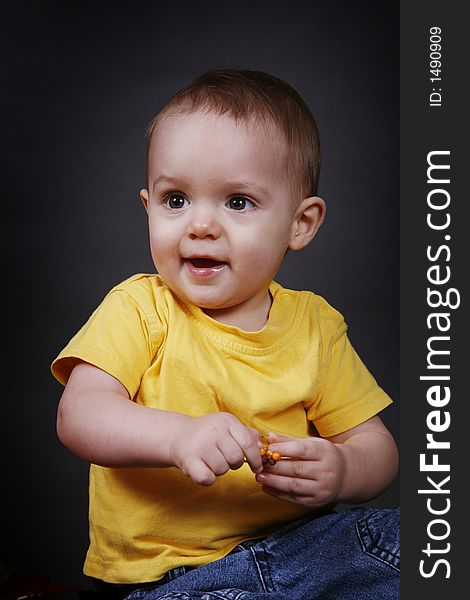 Beautiful baby boy poses on a black background