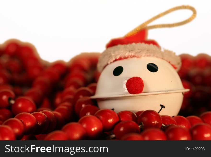 White ball ornament with face on top of red beads garland. White ball ornament with face on top of red beads garland