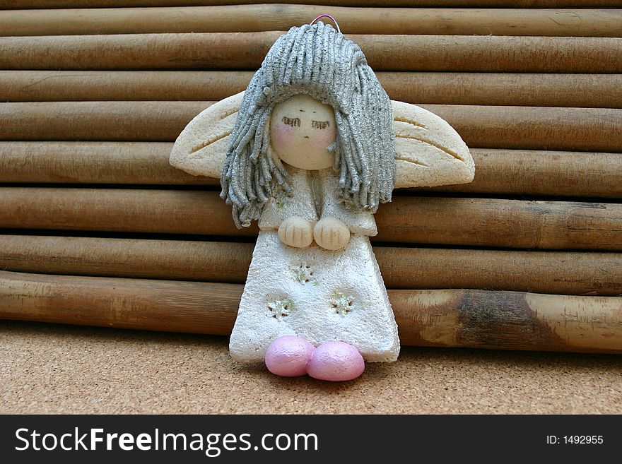 Silver haired shy angel toy keeping his hands and feet together.