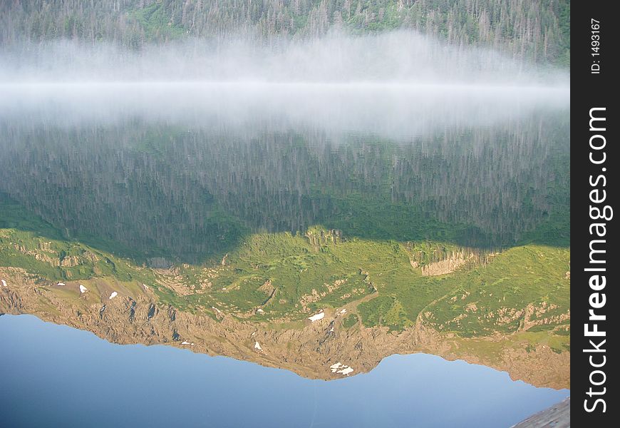 Mountain ridge reflected in still alpine lake. Mountain ridge reflected in still alpine lake