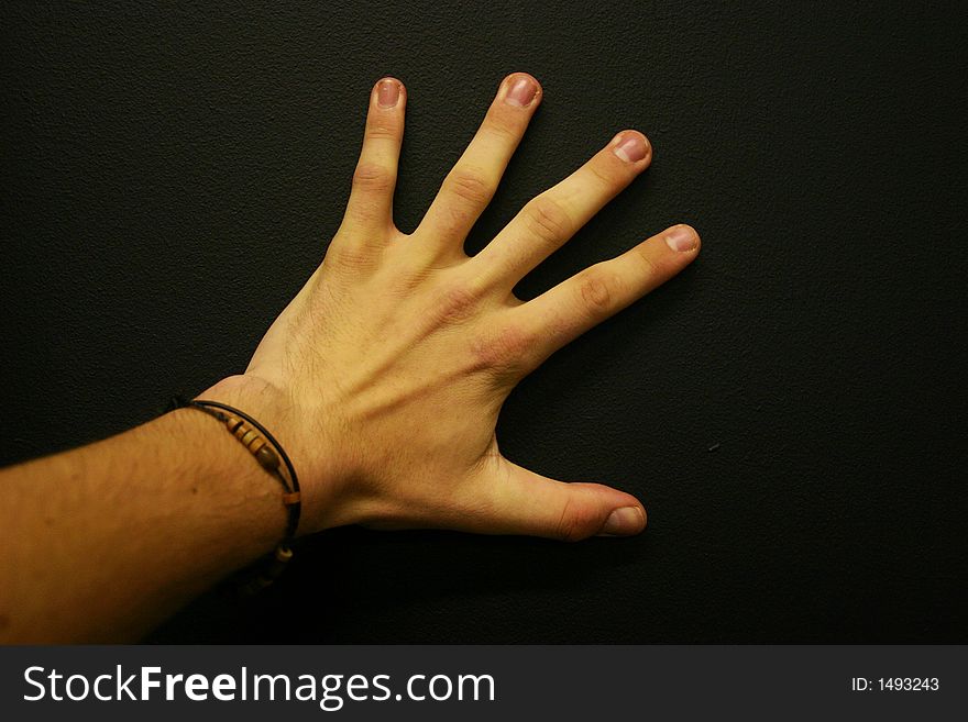 Big and long fingered hand on plain black background. Big and long fingered hand on plain black background