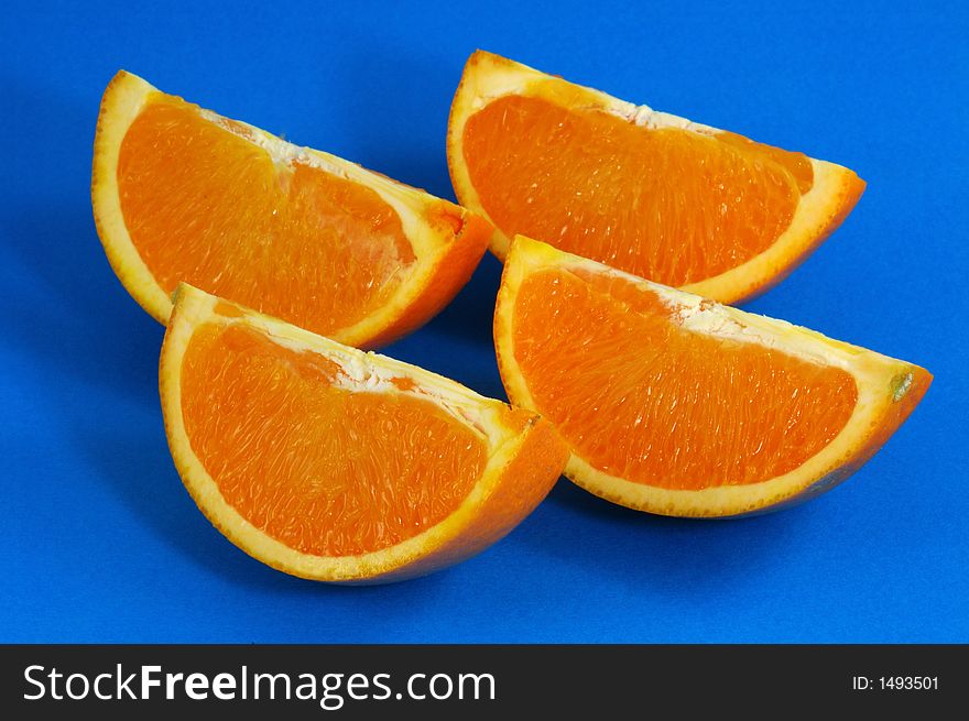 Orange Wedges Over Blue Background. Orange Wedges Over Blue Background