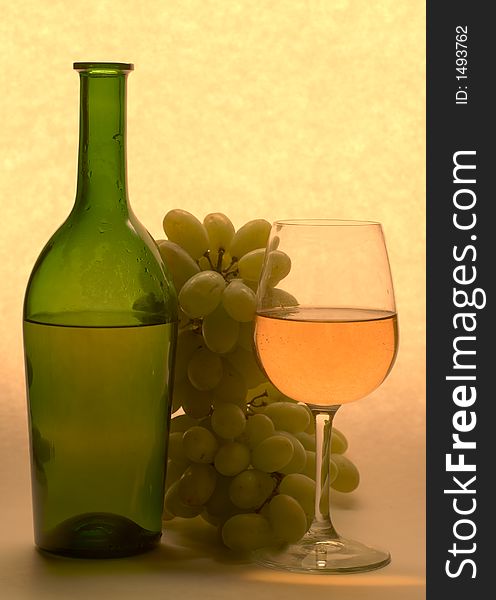 Bottle of wine, glass and grapes on light bakground. Bottle of wine, glass and grapes on light bakground