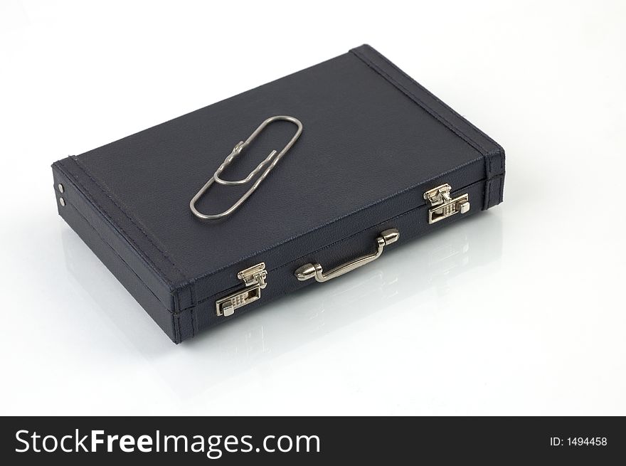 Black toy suitcase with gigantic paper clip ontop