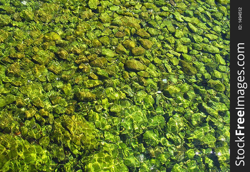 Green stones under the water,  Montenegro country, daylight. Green stones under the water,  Montenegro country, daylight