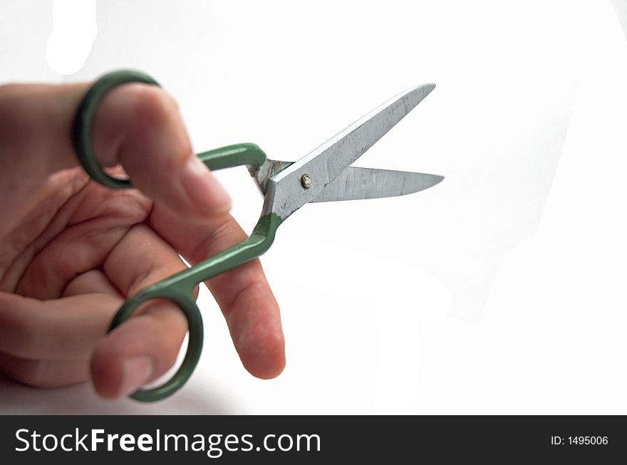 Left hand holding green scissors