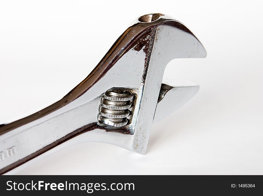 Photo of an chromed adjustable wrench against a white background
