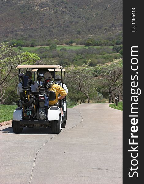 Golfers driving off in golf cart after teeing off